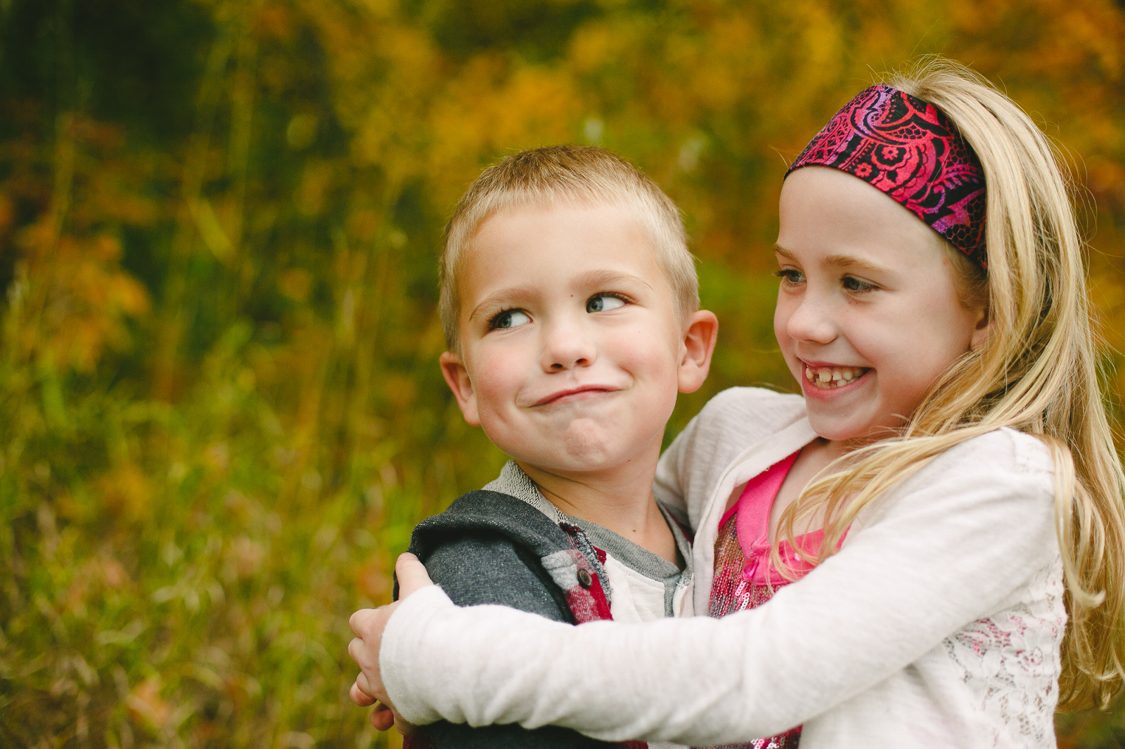 Brother and sister smiling, foliage season