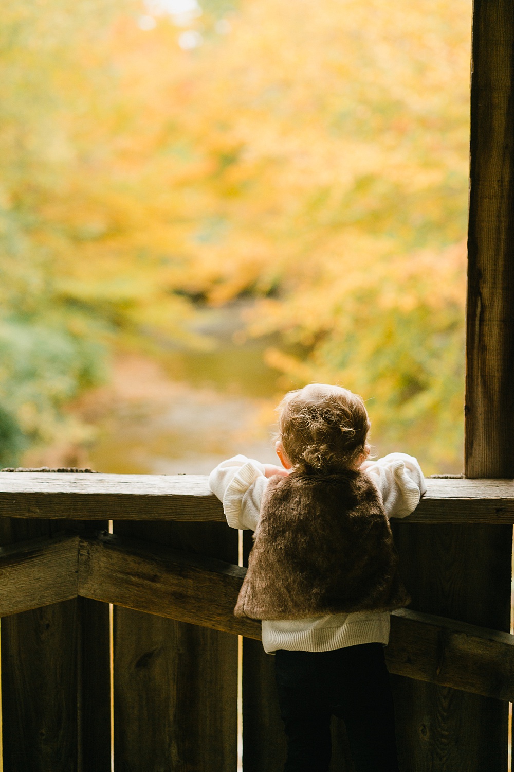 toddler on covered bridge by Vermont family photographer